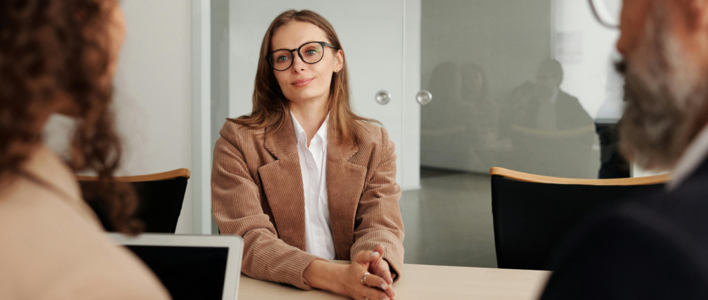Woman in an IT interview, smiling at two interviewers