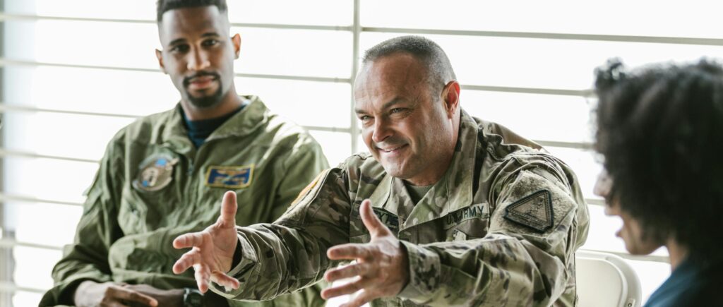 Two veterans seated in a group discussion